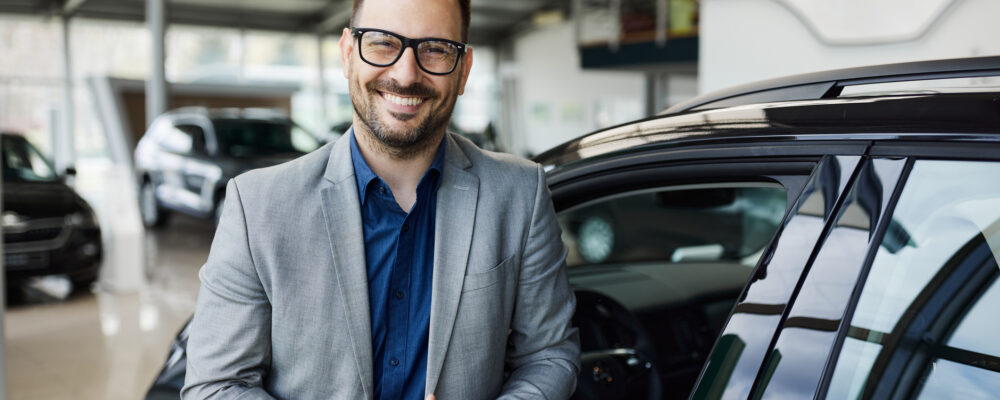 KFZ-Führungskraft steht neben einem Auto